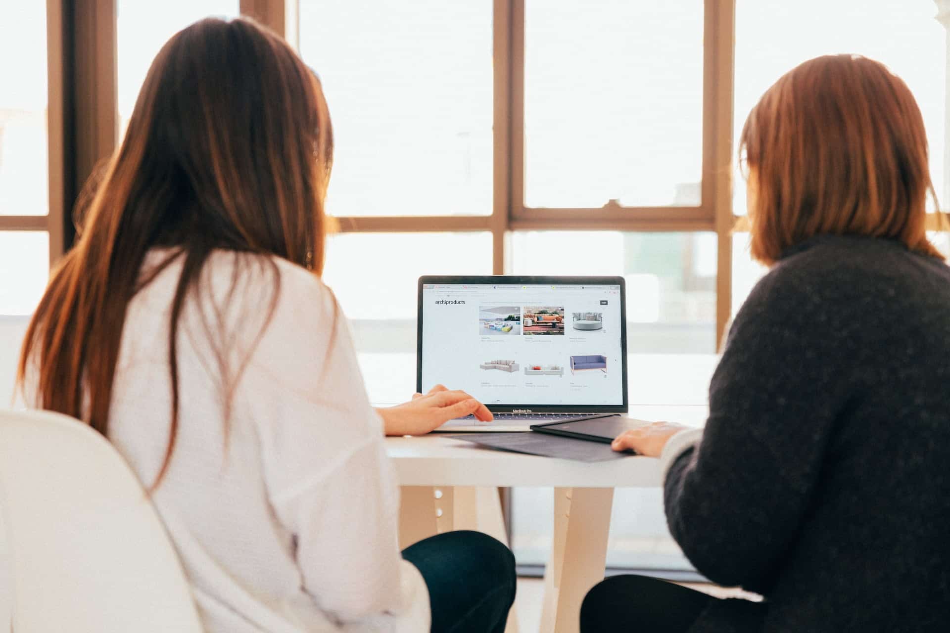 To personer som sidder og kigger på en hjemmeside
