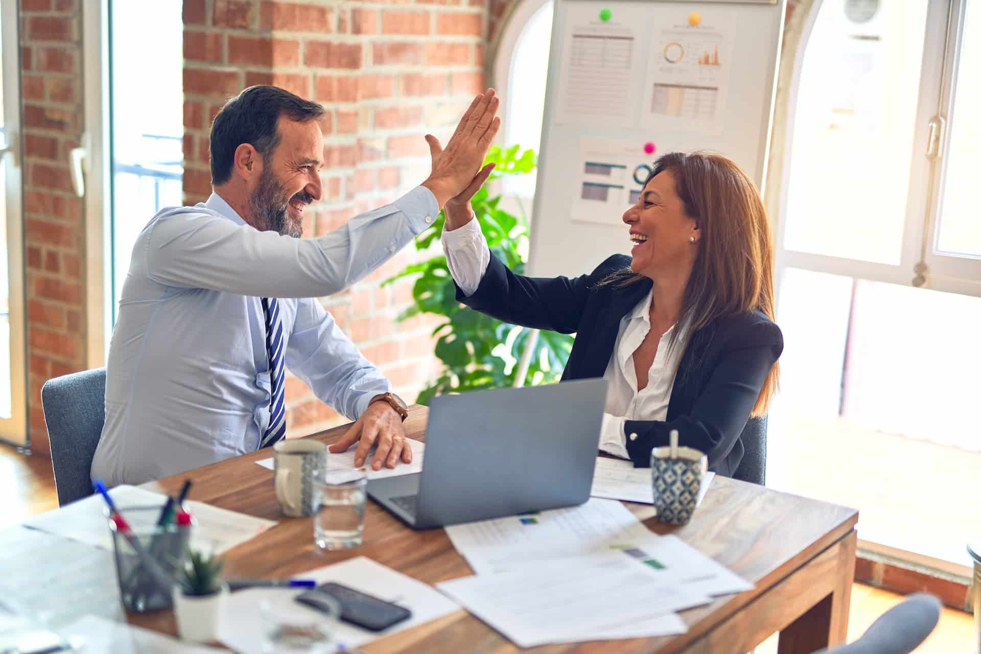 To glade personer, som giver hinanden en high-five